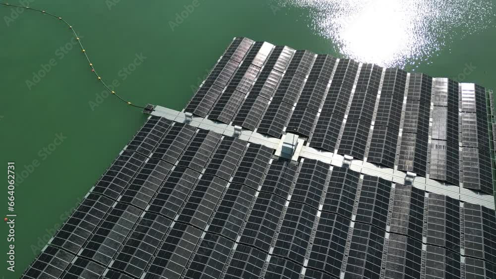 Zoom out einem schwimmenden Solarpark mit vielen Solarmodulen auf dem Wasser von einem See