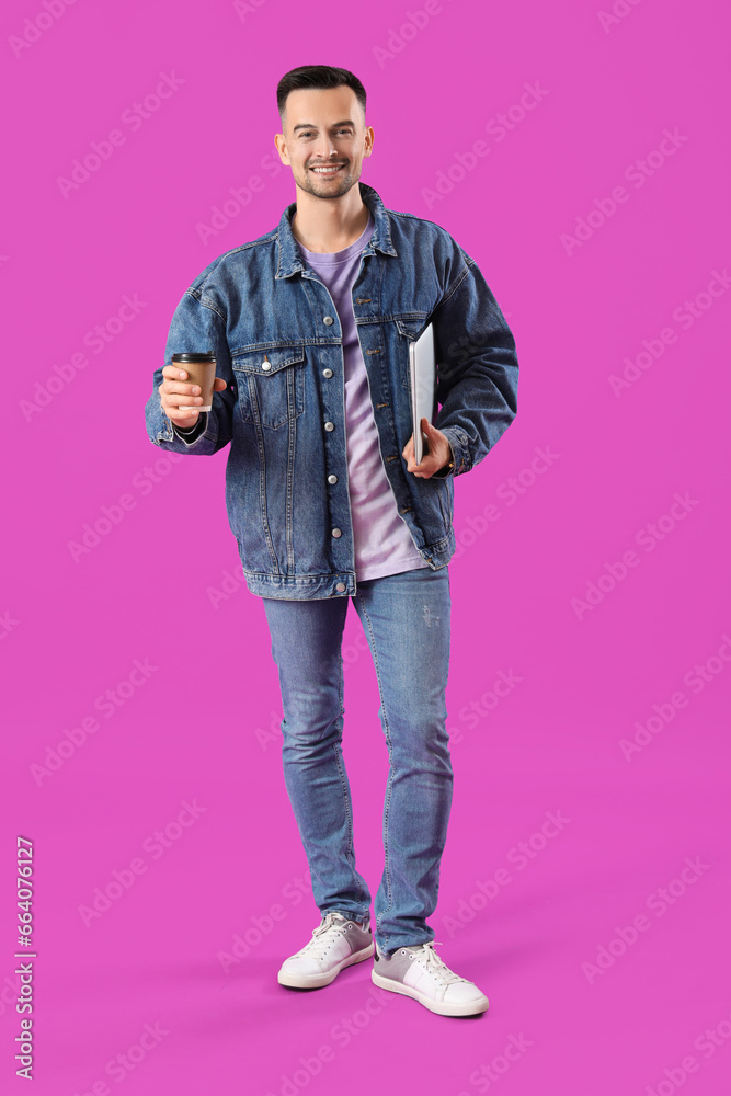 Happy young man with laptop and cup of coffee on purple background Happy young man with laptop and cup of coffee on purple background