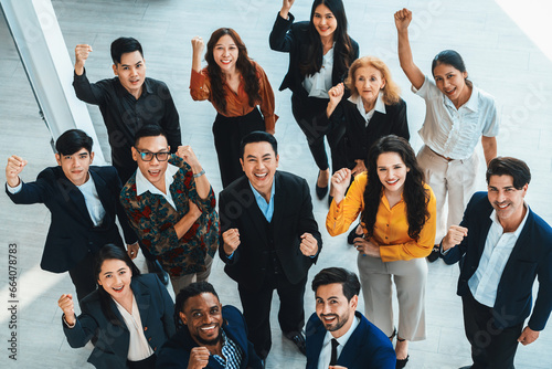 Happy diverse business people celebrating their success project.Top view. Group of successful energetic employees cheer up gratefully while looking at sky with white background. Intellectual. photo