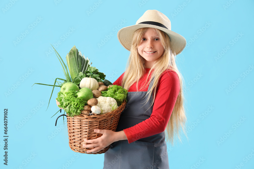 Little farmer with fresh food on blue background