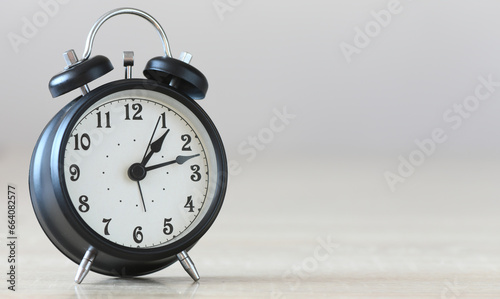 Black alarm clock on a gray background.
