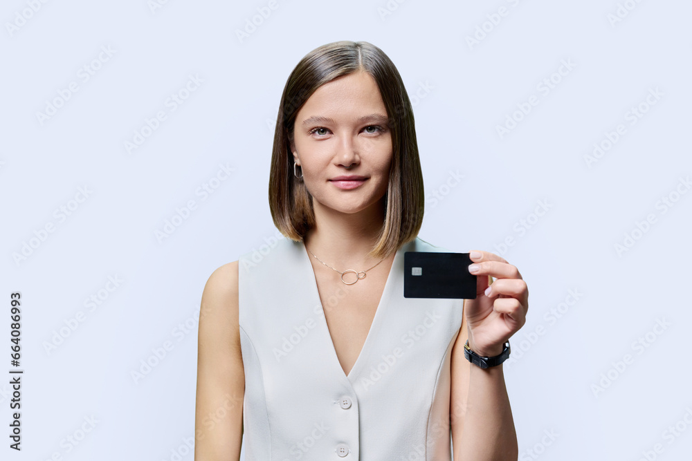 Young woman with bank credit card in hands on white studio background. Young woman with bank credit card in hands on white studio background.