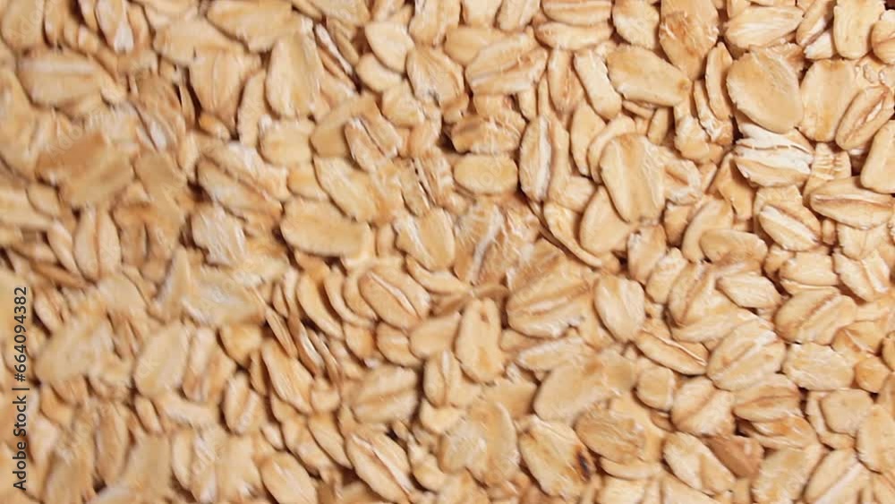 Oat Flakes Background Slowly Rotating Counter-Clockwise - Top View. Scattered Dry Oat Flakes. Healthy Breakfast and Diet Eating Ingredients - Angular Rotation Left Oat Flakes Background Slowly Rotating Counter-Clockwise - Top View. Scattered Dry Oat Flakes. Healthy Breakfast and Diet Eating Ingredients - Angular Rotation Left