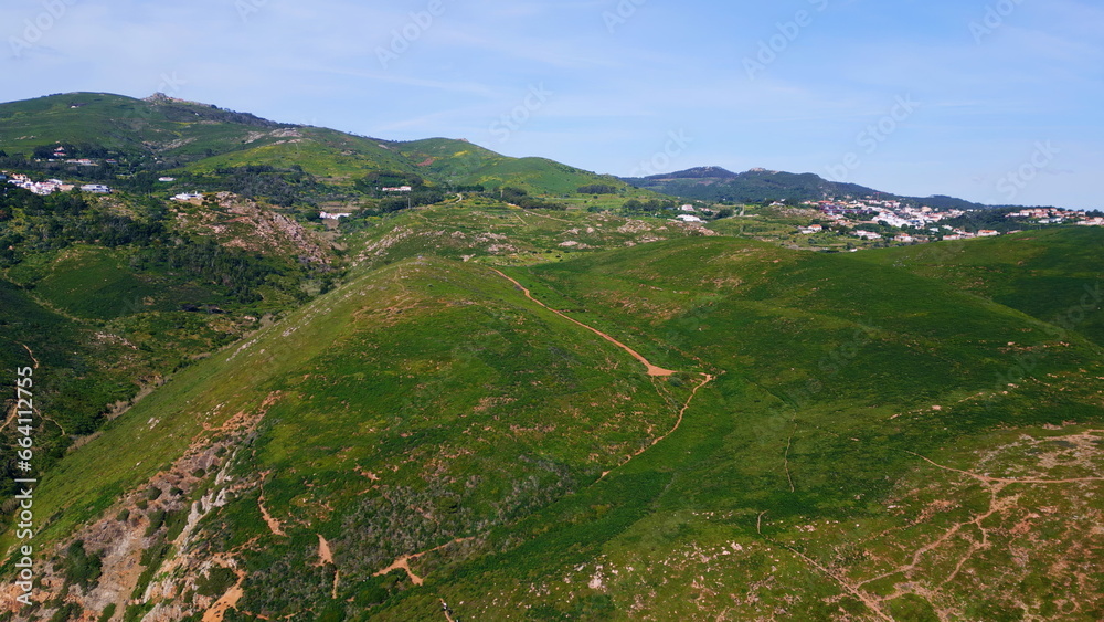 Fototapeta premium Panoramic view grassy slopes under cloudy sky. Mountain hills covered greenery