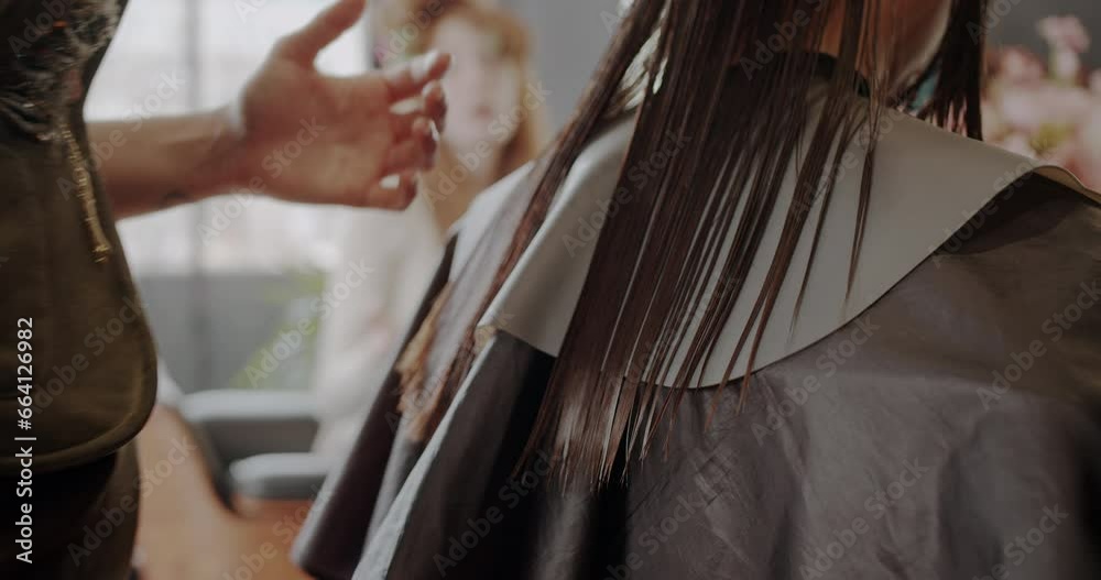 Cutting the hair of a beautiful brunette lady in hairstyling studio, close up, trucking motion Cutting the hair of a beautiful brunette lady in hairstyling studio, close up, trucking motion