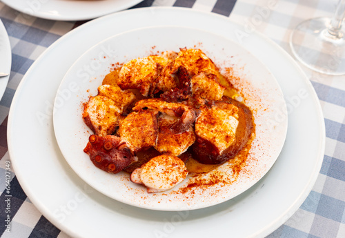 Galician dish Pulpo a la gallega of boiled octopus sprinkled with fragrant smoked paprika traditionally served with side dish of potato slices. Popular seafood appetizer..