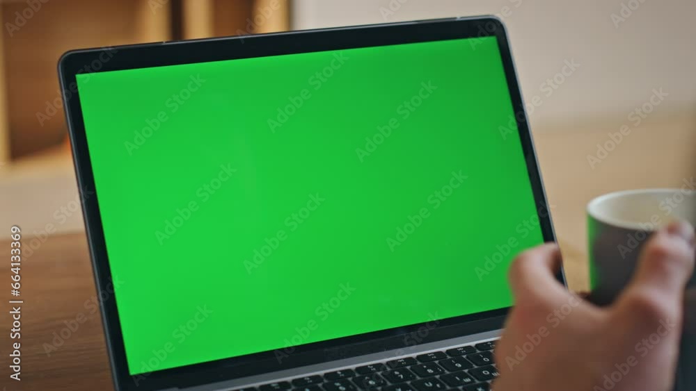 Businessman video calling greenscreen laptop holding coffee cup close up. Businessman video calling greenscreen laptop holding coffee cup close up.