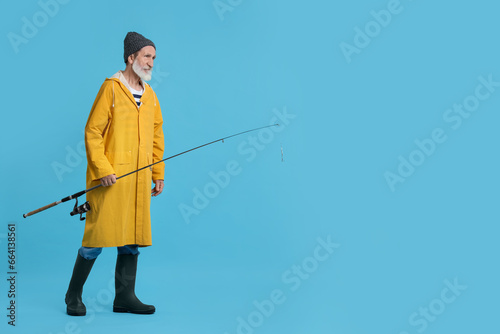 Fisherman with fishing rod on light blue background, space for text