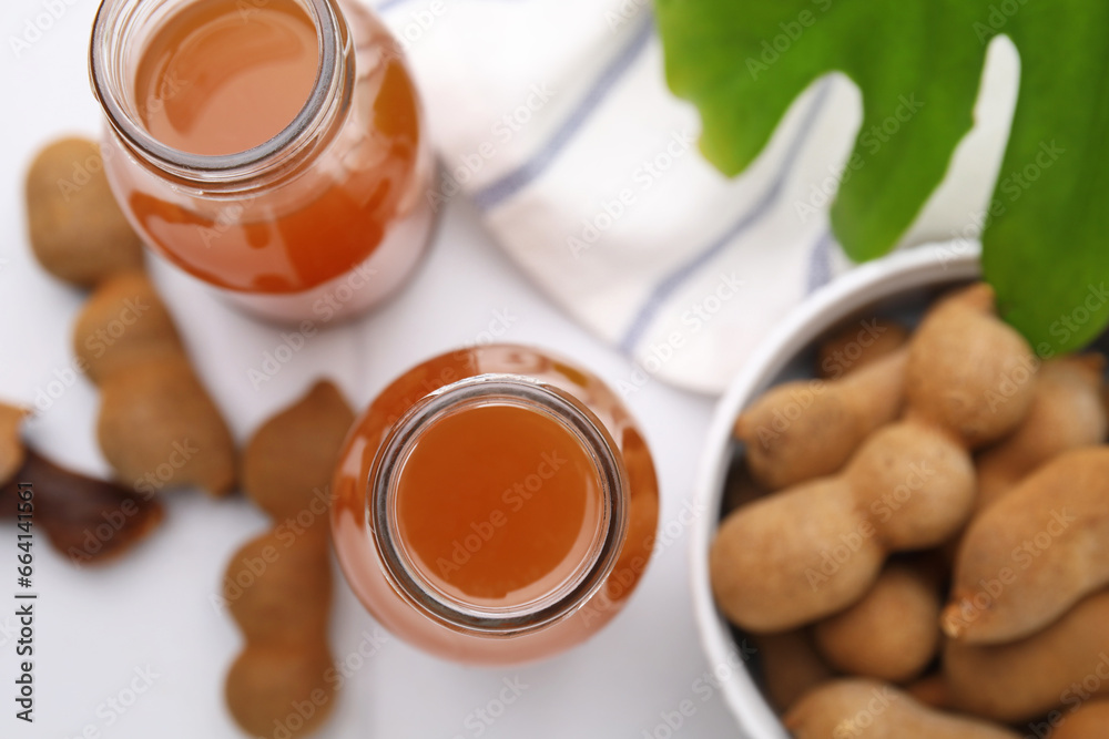 Tamarind juice and fresh fruits on white table, flat lay Tamarind juice and fresh fruits on white table, flat lay