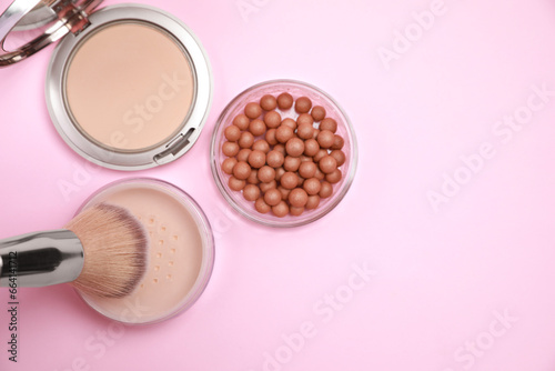 Applying face powder on brush on pink background, flat lay. Space for text