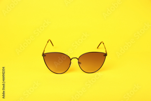 Stylish pair of sunglasses on yellow background