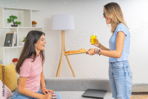 Girl offering pizza to her flat mate at home photo