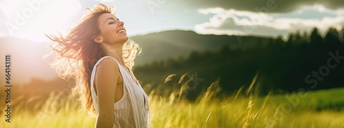 Backlit Portrait of calm happy smiling free woman with closed eyes enjoys a beautiful moment life on the fields at sunset photo
