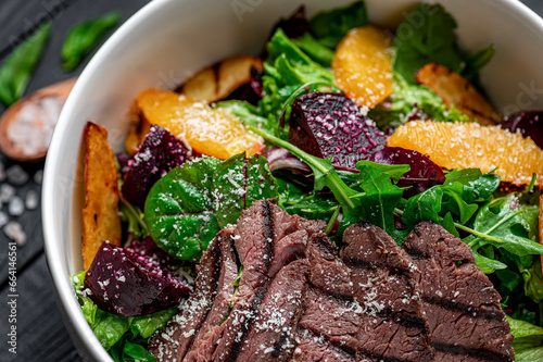 Salad with roast beef and caramelized beets with orange fillet, potatoes, parmesan, salad mix and olive oil