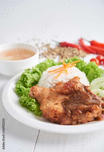 Fried chicken chop with pepper sauce served with rice and vegetables. Selective focus, isolated in white background