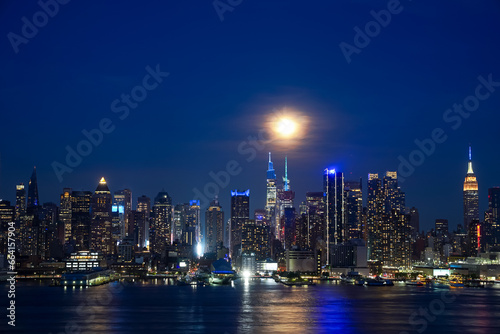 Hudson River reflects the lights and New York Skyline at night © Bryan