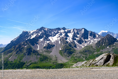 Narrow mountains road from Col de Lautaret to Col du Calibier, Mountains and alpine meadows views of Massif des Ecrins, Hautes Alpes, France in summer photo