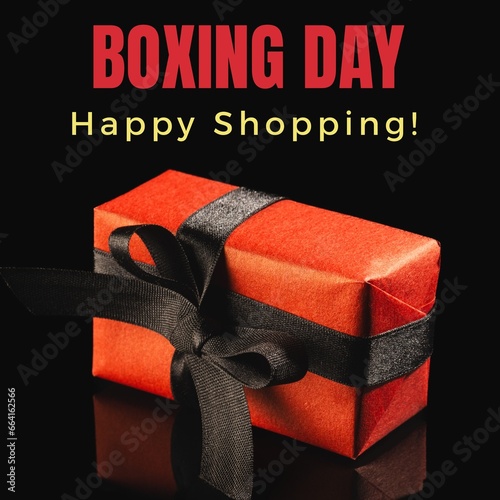 Composite of boxing day and happy shopping text over red gift box on black background, copy space