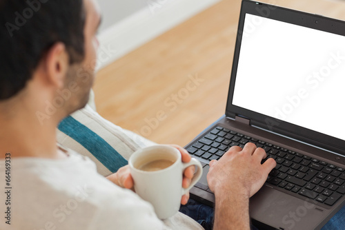 Digital png photo of biracial man with cup of coffee using laptop on transparent background