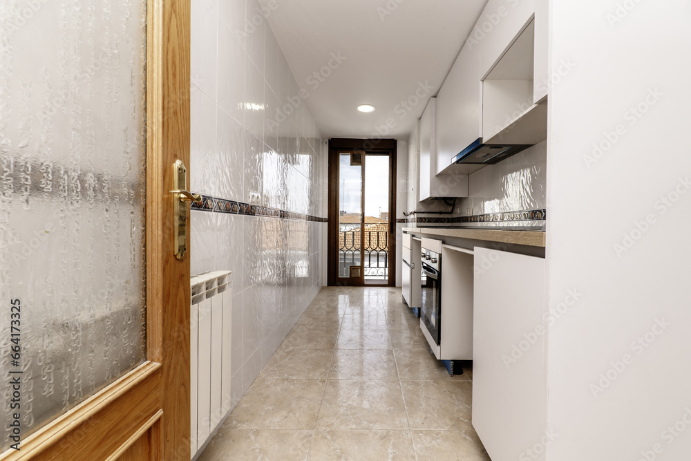 Room with an elongated kitchen with furniture on one side of the room, a wooden countertop and access to a terrace Room with an elongated kitchen with furniture on one side of the room, a wooden countertop and access to a terrace