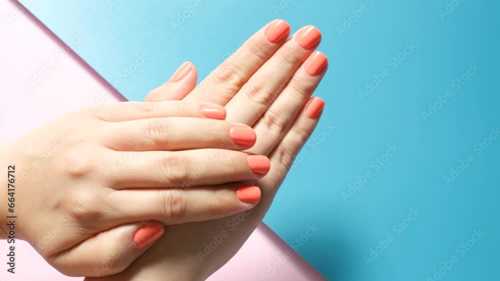 Female hands with manicure on pink and blue background close-up. Female hands with manicure on pink and blue background close-up.