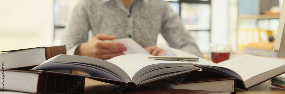 Female employee reads books to find information for research Female employee reads books to find information for research