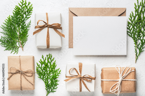 Christmas gift craft boxes, craft paper envelope and blank card and thuja branches. Christmas or holiday card. Boxing Day.