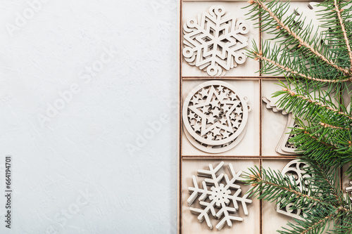Christmas background, postcard. Christmas wooden decorations in a box and fir branches, holiday in eco style.Christmas eco-friendly decorations. Place for test.