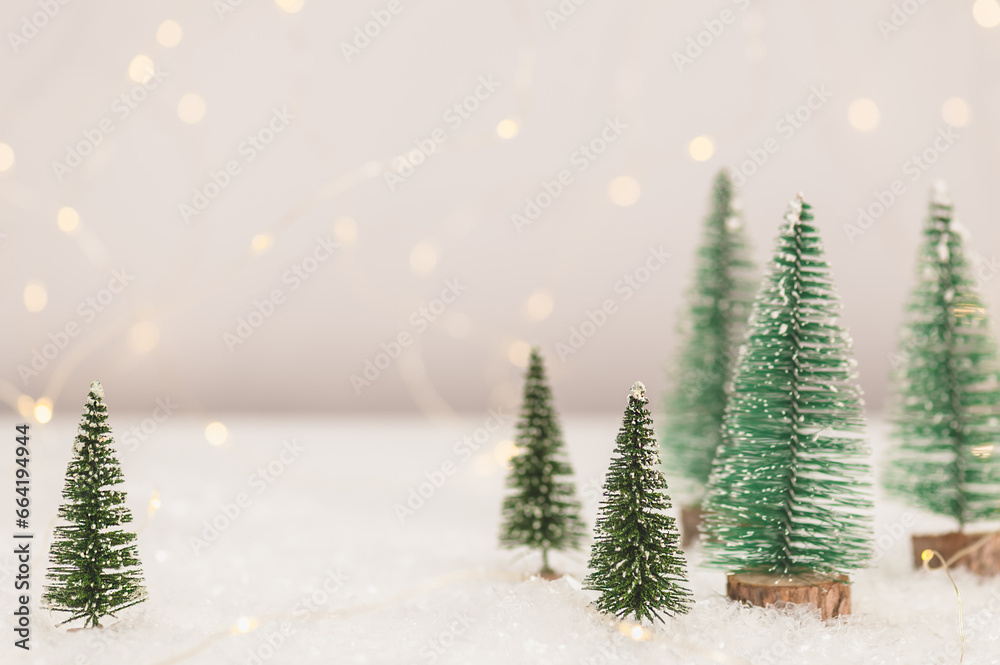 Artificial snow, artificial Christmas trees against a background of blurry lights. Christmas gifts concept. Christmas background. Selective focus.