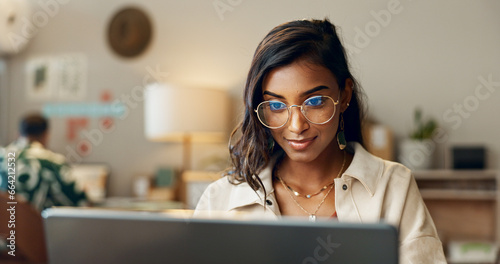 Business, woman and reading on laptop in office for research, feedback and supply chain for business. Indian, person and typing on pc for logistics, stock administration or package distribution data