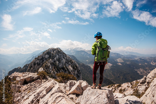 A girl with a backpack on a hike. adventure in the mountains. hiking with a backpack. girl with a backpack in the high mountains. Rock climbing and mountaineering concept.