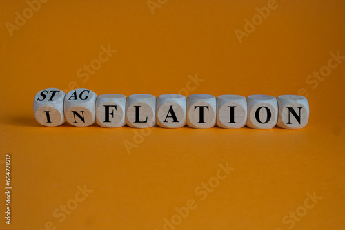 Stagflation or inflation symbol. Turned wooden cubes and changed the concept word inflation to stagflation. Beautiful orange background, copy space. Business stagflation or inflation concept.