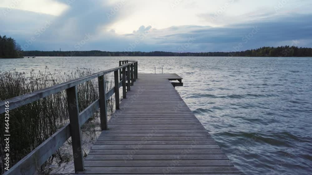 Empty wooden pier at a lake on a windy autumn evening Empty wooden pier at a lake on a windy autumn evening