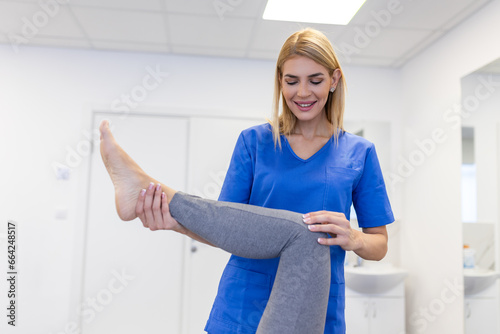 Physiotherapist working with patient in clinic, closeup. A Modern rehabilitation physiotherapy worker with senior client, Physical therapist stretching patient knee photo