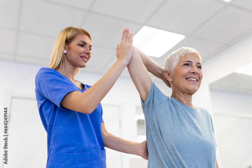 Obraz premium Doctor or Physiotherapist working examining treating injured arm of senior female patient, stretching and exercise, Doing the Rehabilitation therapy pain in clinic.