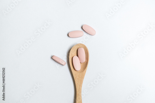 vitamin in wooden spoon on white background, Dietary supplement healthcare product.