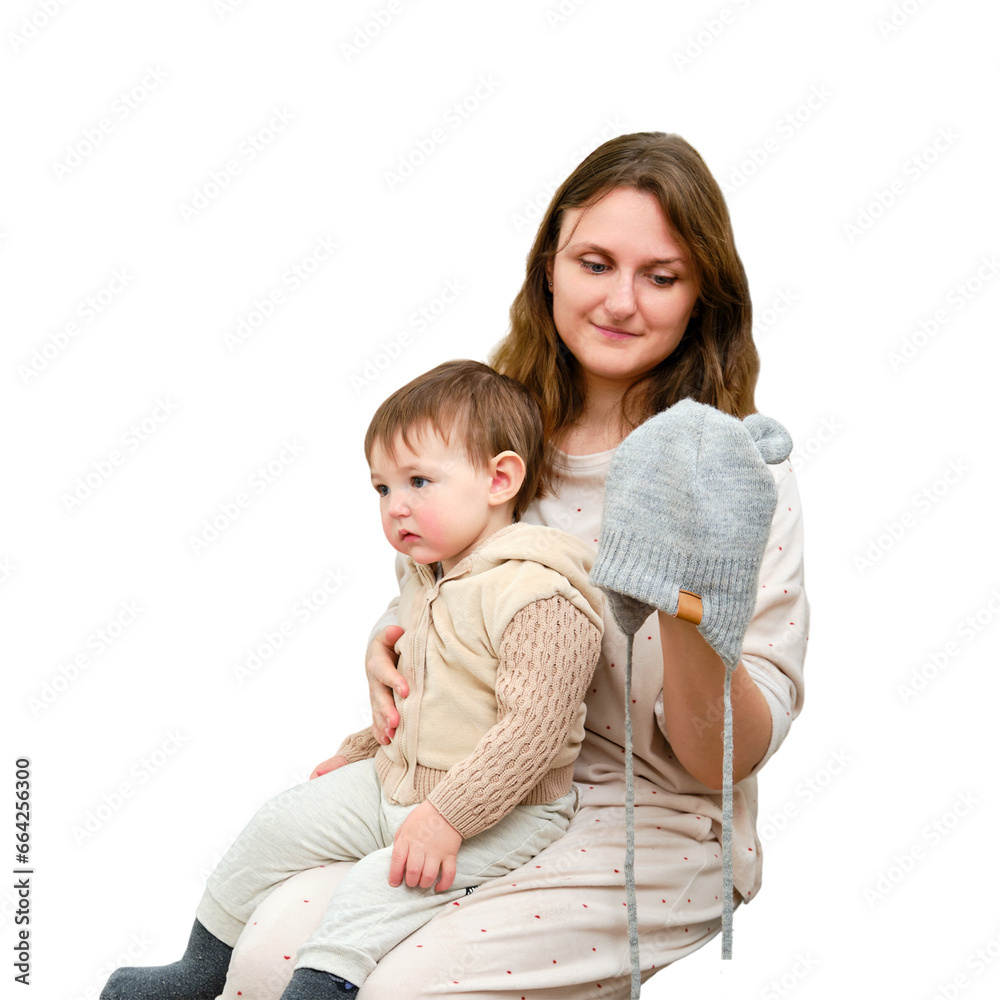 Mother puts a warm scarf on the toddler baby, isolated on a white background. Woman mom dressing warm clothes on child for winter walk in cold weather. Kid aged one year and three months Mother puts a warm scarf on the toddler baby, isolated on a white background. Woman mom dressing warm clothes on child for winter walk in cold weather. Kid aged one year and three months