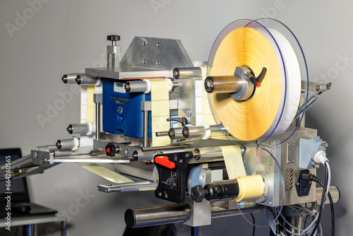 Applicator of self-adhesive labels in a drum roll. photo