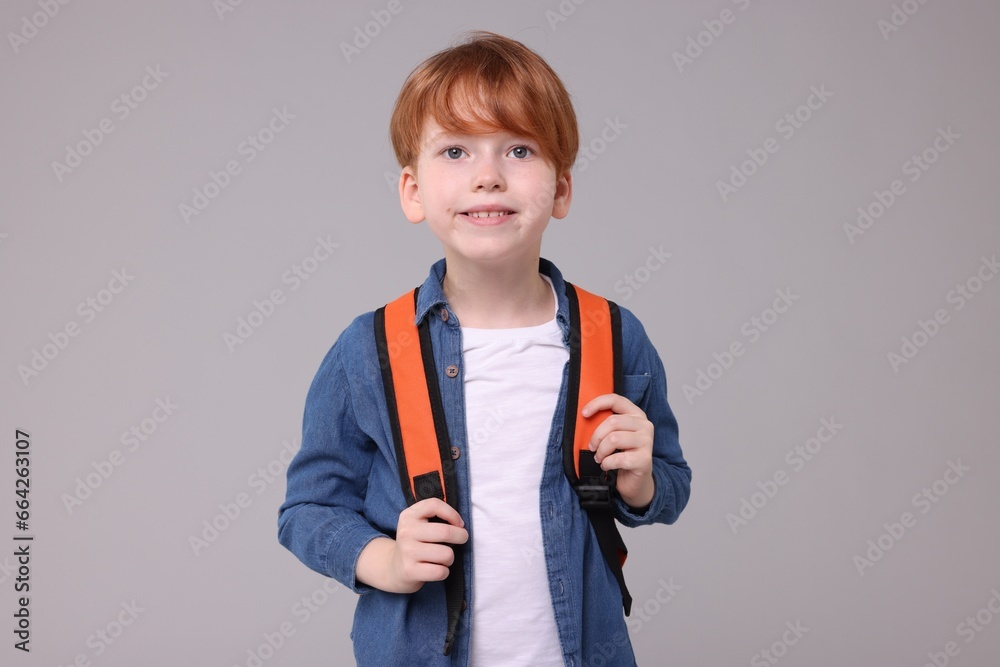 Portrait of happy schoolboy on grey background Portrait of happy schoolboy on grey background