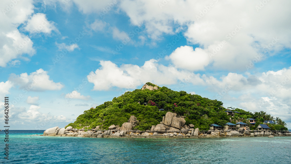 Fototapeta premium Scenic view tropical paradise with peaceful resort, rocky coastline, clear turquoise sea with coral reef against cloud sky. Koh Nangyuan Near Koh Tao Island, Thailand.