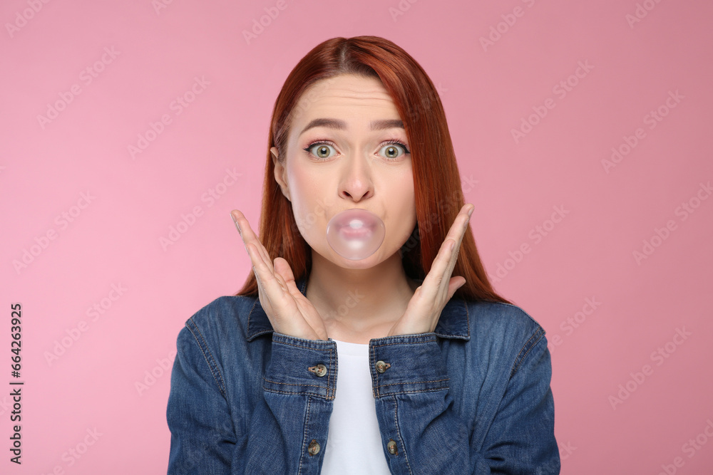 Surprised woman blowing bubble gum on pink background Surprised woman blowing bubble gum on pink background