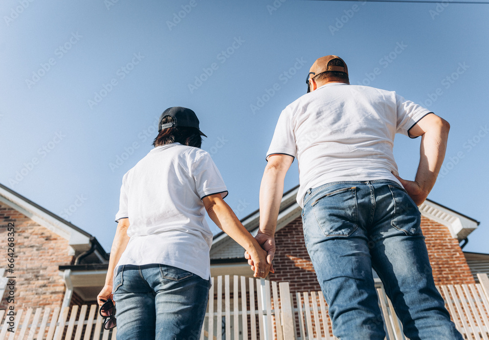 A couple in love looks at their dream house. a man and a woman look at their house.