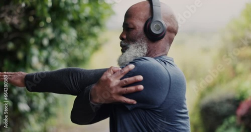 Old man, African with headphones and stretching in park, running and cardio with fitness, health and listen to music. Warm up, start run and audio streaming, podcast or radio with vitality outdoor photo
