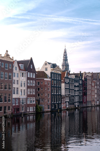 Old buildings of Amsterdam near river. Reflections in the morning on a canal of Amsterdam, Holland 