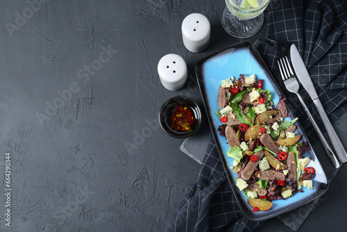 Delicious salad with beef tongue and cheese served on black textured table, flat lay. Space for text