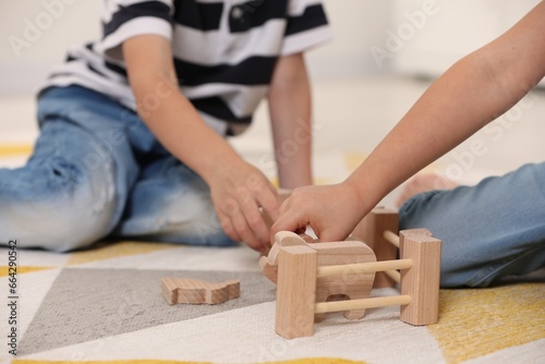 Little children playing with set of wooden animals indoors  closeup
