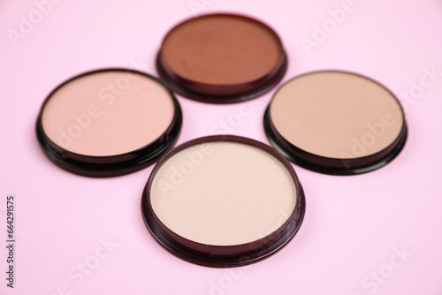 Different face powders on pink background. Decorative cosmetic