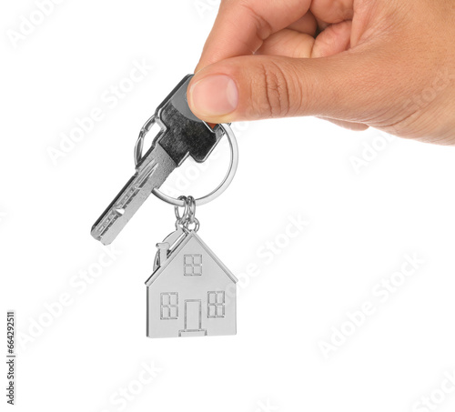 Woman holding key with metallic keychain in shape of house on white background, closeup