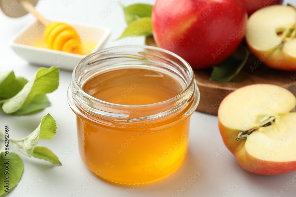 Sweet honey and fresh apples on white table, closeup Sweet honey and fresh apples on white table, closeup