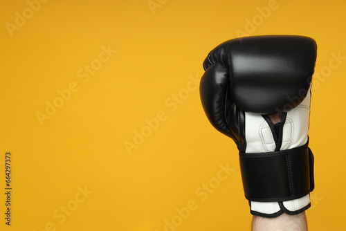 Fototapeta Naklejka Na Ścianę i Meble -  Black boxing gloves on a yellow background